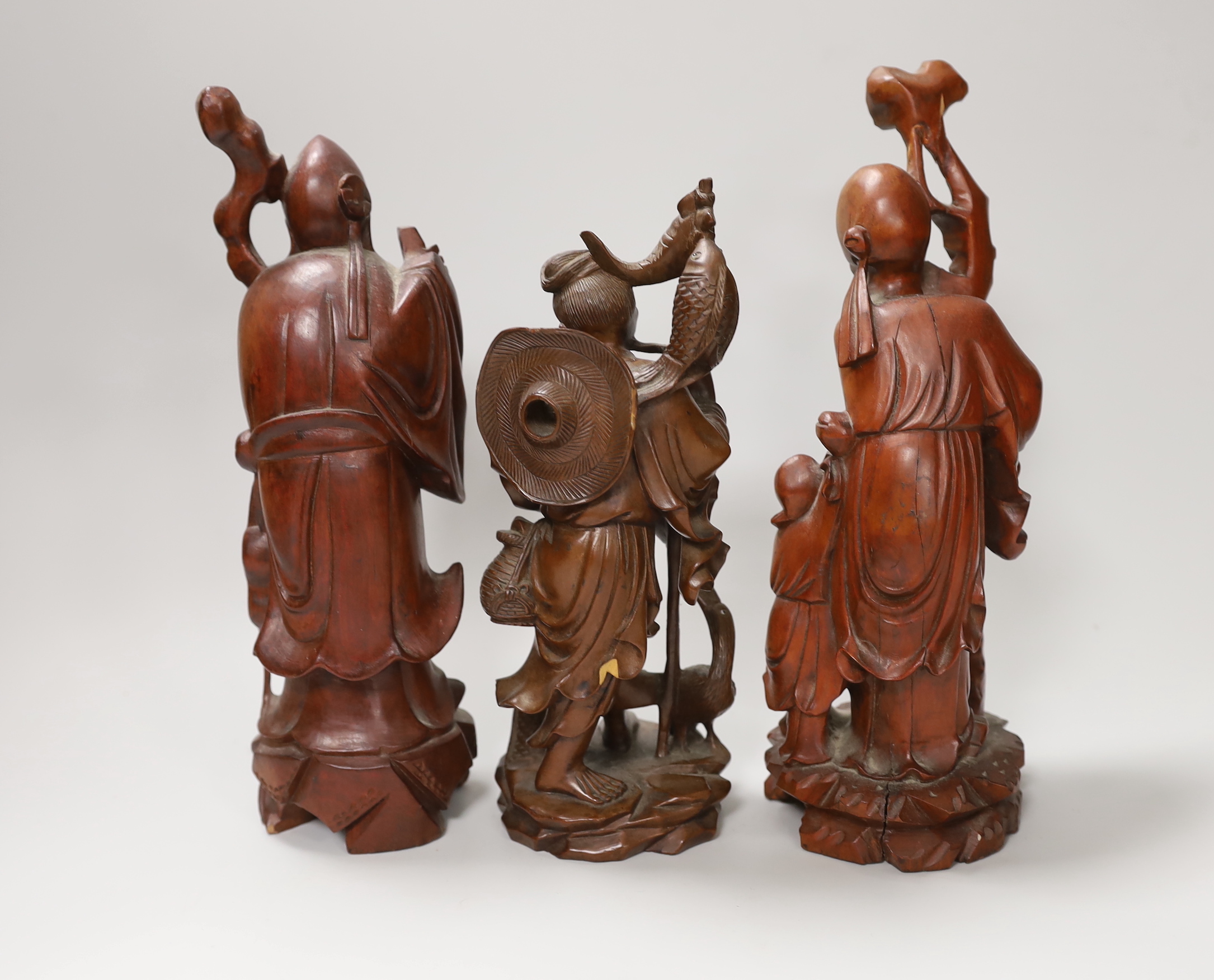 Three Chinese carved wood figures of Shou Lao and a fisherman, the largest 25cm high